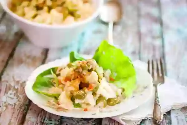 Serving of low carb macaroni salad made with cauliflower on a vintage plate. a serving dish is in the background.