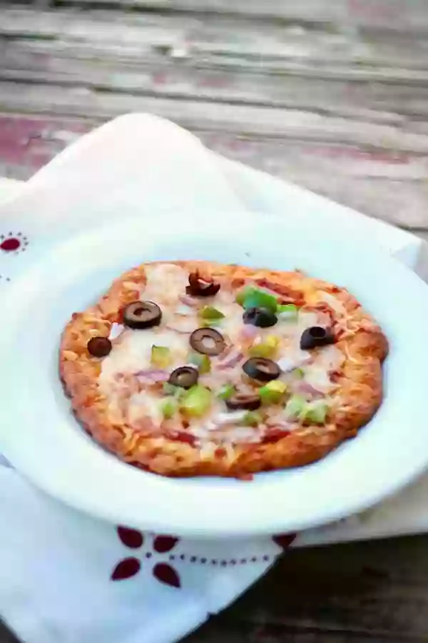 Just 2 net carbs! Low carb pizza crust recipe is quick and easy and has the perfect texture! From Lowcarb-ology.com