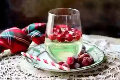 balloon glass filled with low carb white wine spritzer, with frozen cranberries floating in it. Feature image