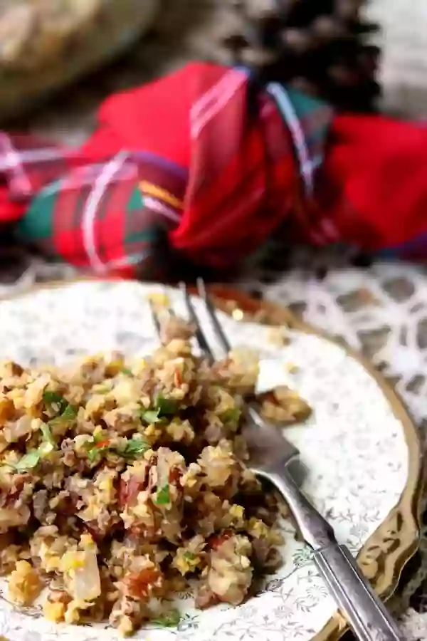 Close up of low carb stuffing recipe with a fork on the plate and red plaid napkin in the background.