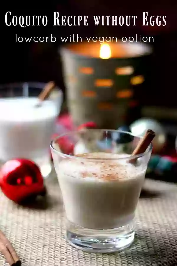 A glass of creamy coquito cocktail dusted with cinnamon and garnished with a cinnamon stick. Title image for coquito recipe without eggs