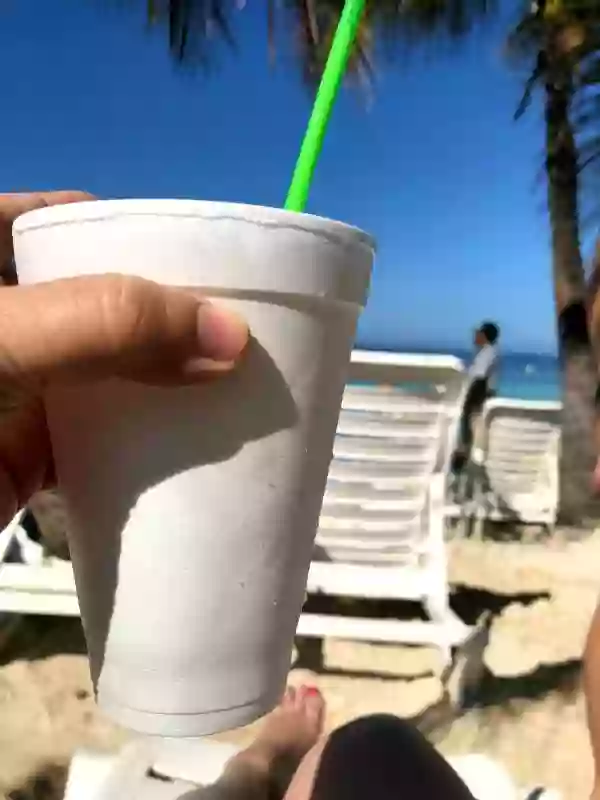 hand holding a styrofoam cup on a sunny beach - vacation image for mule recipe post