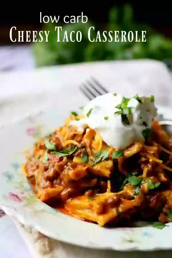 A plate with low carb taco casserole on it, topped with cheese and sour cream - title image 