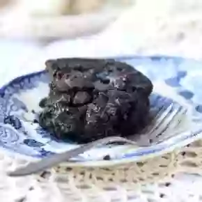 Dark chocolate keto brownie on a blue willow plate with a fork - recipe image