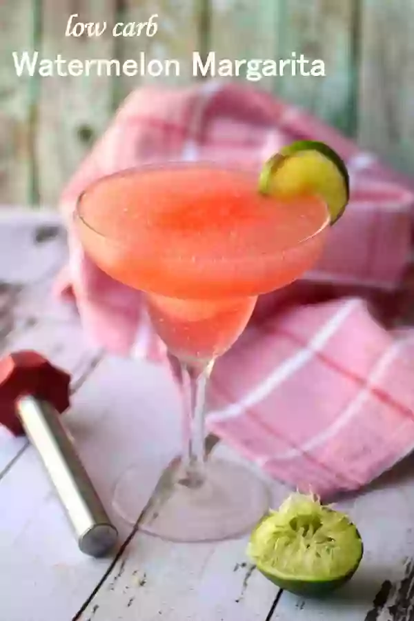 Slushy red skinny watermelon margarita in a clear glass. A red and white tea towel is in the background - title image