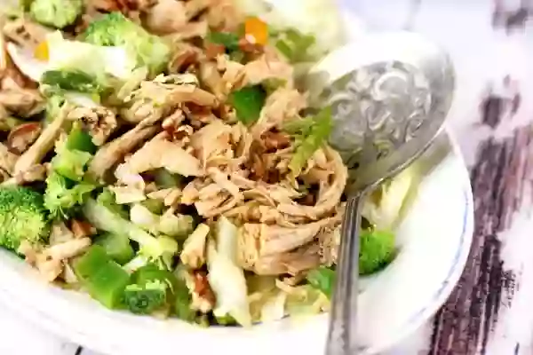 Feature image - Hunan Chicken salad has pieces of cooked chicken over a bed of salad greens and crunchy vegetables