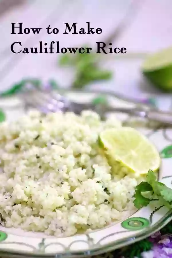 Closeup of cauliflower rice on a green and white plate garnished with a lime slice. Title image