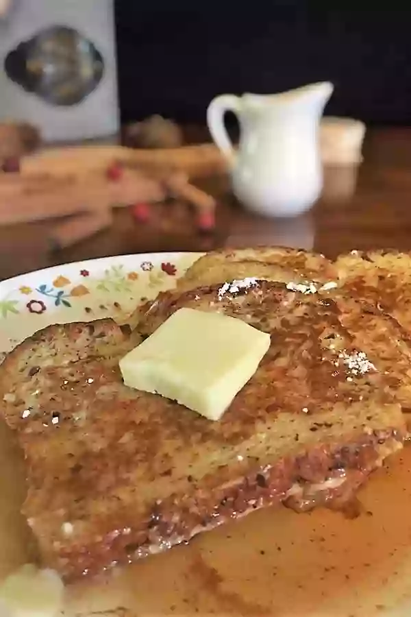 Low carb cinnamon French toast drizzled in syrup with melting butter on top. Title image.
