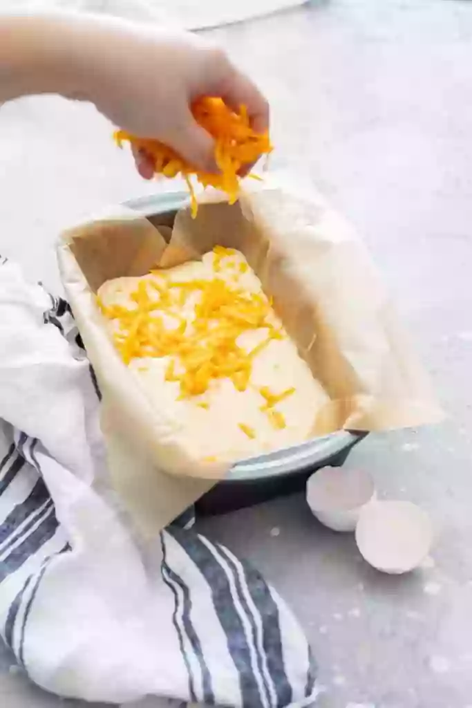 Sprinkling Cheese on Bread Mixture