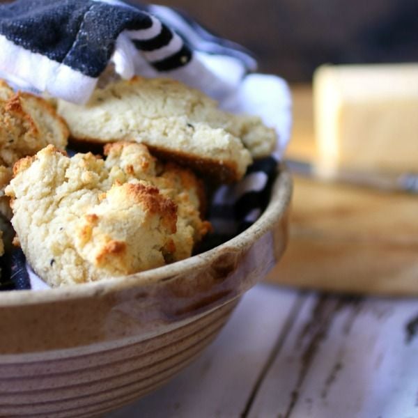 Finished Low Carb Sour Cream Biscuits in an Earthenware Bowl With a Black and White Towel Over the Top