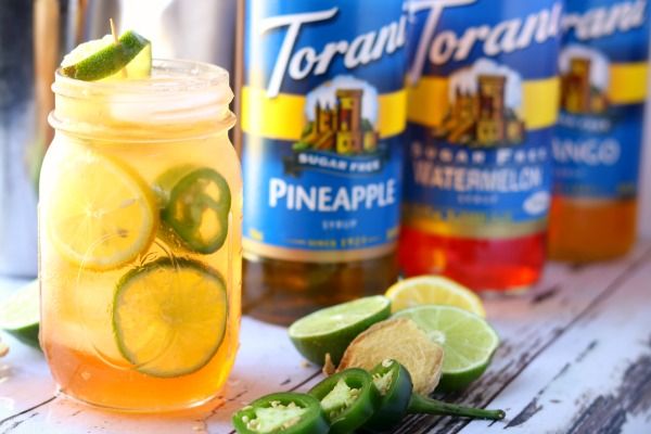 Horizontal image of the finished cocktail with Torani syrups in the background