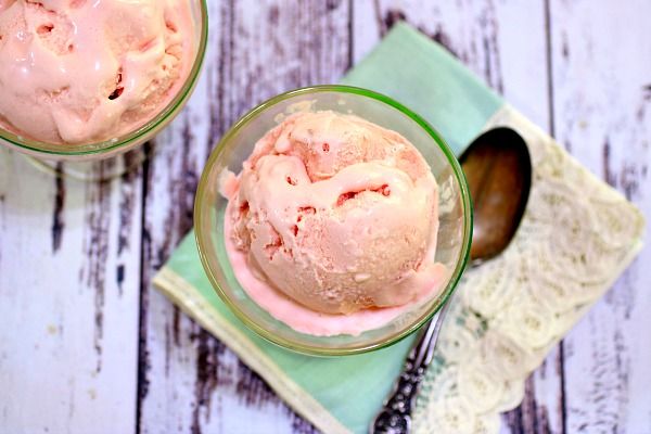 A closeup of a scoop of low carb strawberry ice cream in a vintage ice cream dish.